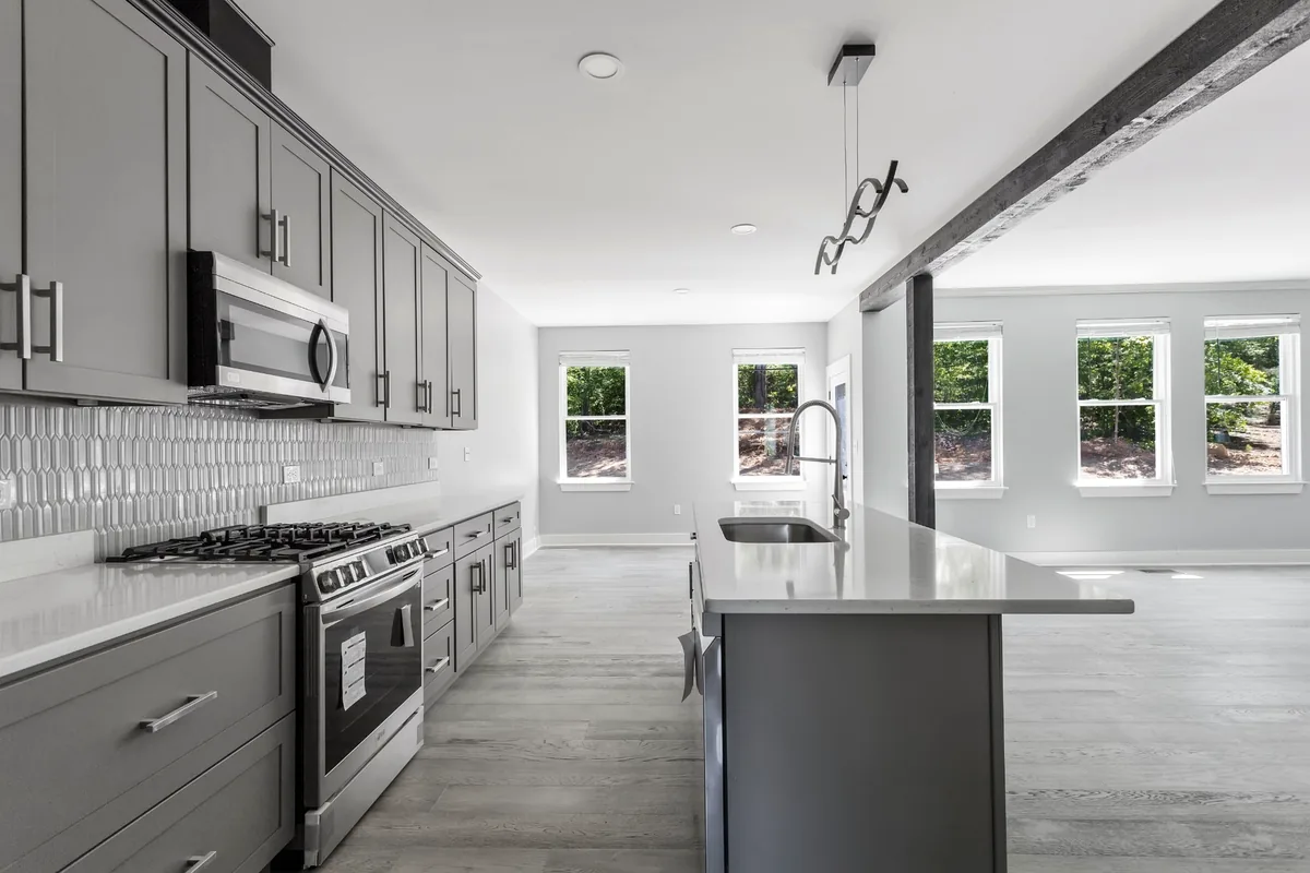 Modern residential kitchen with large island and gray cabinetry