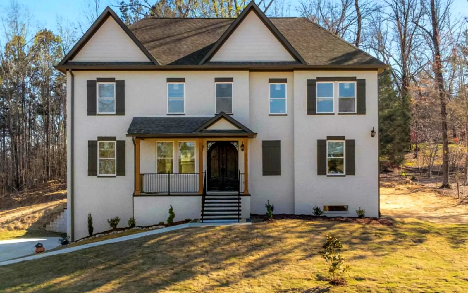 Two-story white brick residential project with dark trim and front porch